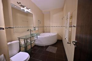 a bathroom with a tub and a toilet and a sink at Hotel Magic GT Trivale in Piteşti +70 photos
