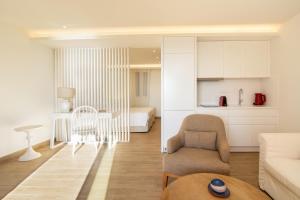 a living room with a couch and a chair and a table at Glyfada Glow Suites by CorfuEscapes in Glyfada