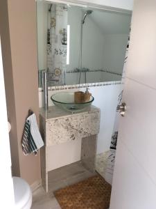 y baño con lavabo de cristal y espejo. en Apartamento Los Pinos en San Miguel de Salinas