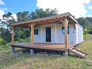 a tiny house with a porch and a deck at Villa Océanne in Grand-Bourg