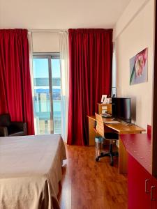 a hotel room with a bed and a desk with a computer at Executive Hotel in Forlì +33 photos