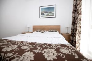a bedroom with a bed with a brown and white blanket at Apartament IKAR blisko morza in Rewal