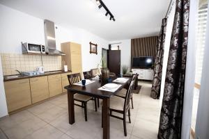 a kitchen and dining room with a table and chairs at Apartament IKAR blisko morza in Rewal