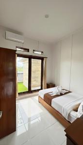 a bedroom with a large bed and a window at Amerthya Villa in Banjar