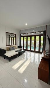 a living room with a couch and a table at Amerthya Villa in Banjar