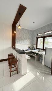 a large kitchen with a counter and a refrigerator at Amerthya Villa in Banjar