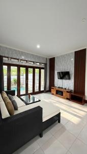 a living room with a couch and a tv at Amerthya Villa in Banjar +1 photo