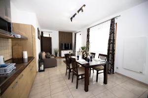 a kitchen and dining room with a table and chairs at Apartament IKAR blisko morza in Rewal +32 photos