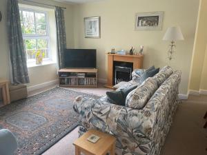 a living room with a couch and a television at Carpenter's Cottage in Matlock