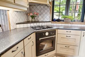 a kitchen with white cabinets and a stove top oven at Mountain Cabin With Great Views in Austbygdi