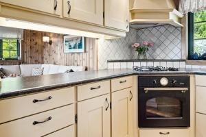 a kitchen with white cabinets and a black oven at Mountain Cabin With Great Views in Austbygdi +32 photos