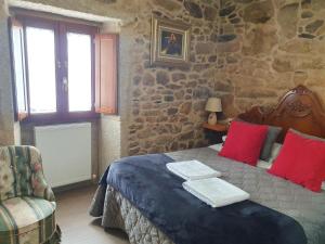 a bedroom with a bed in a stone wall at la pallota de san cristobal in Palas de Rei