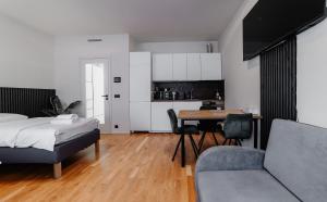 a bedroom with a bed and a table and a kitchen at Jasminn Apartments in Prague