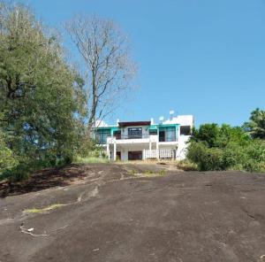 a house on a hill with a driveway in front of it at Rock House Villa in Kandy