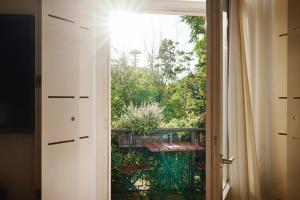 an open door to a balcony with a view of a garden at Hotel Weitzer Graz - Centre of Graz in Graz