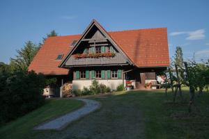 une maison avec un toit orange et des fleurs sur la fenêtre dans l'établissement Ferienhaus Neubauer, à Spielfeld