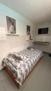 a bedroom with a bed with a comforter on it at Alure 1 in Belo Horizonte