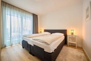 a bedroom with a large bed and a large window at Haus Mühlentrift in Cuxhaven