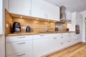 a kitchen with white cabinets and a sink at Haus Mühlentrift in Cuxhaven +41 photos