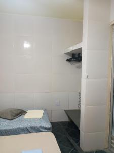 a small room with a bed and a shelf at Casa Hum com cozinha americana in Araruama