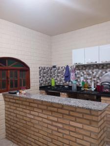a kitchen with a brick counter top in a room at Casa Hum com cozinha americana in Araruama