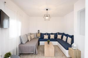a living room with a blue and white couch at The Eagle Merchia Mykonos in Merchia Beach