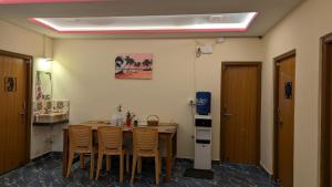 a room with a table and chairs and a refrigerator at Raindrop Homestay Havelock in Sir William Peel Island +11 photos