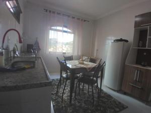 a kitchen with a table and chairs and a refrigerator at Maxi conforto e vista para o Itacolomi in Ouro Preto
