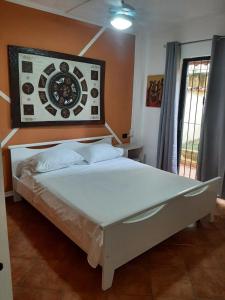 a bed in a room with a clock on the wall at Palm Beach Resort in Boca Chica +26 photos