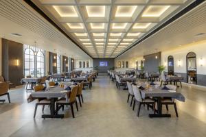 a restaurant with tables and chairs in a room at Hotel Neptune Mansingh Inn in Morbi