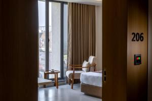 a hotel room with a bed and a chair and a window at Hotel Neptune Mansingh Inn in Morbi