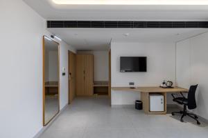 an office with a desk and a chair and a television at Hotel Neptune Mansingh Inn in Morbi