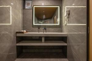 a bathroom with a sink and a mirror at Hotel Neptune Mansingh Inn in Morbi +21 photos