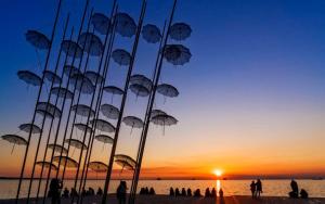 a sculpture of umbrellas on a beach at sunset at Le Grace, Urban Retreat near Near CityCenter & Sea in Thessaloniki