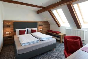 a bedroom with a bed with red pillows at Gasthaus Alter Wirt in Oberneuching
