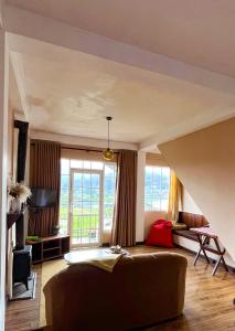 a living room with a couch and a large window at Medalin Lake Gregory in Nuwara Eliya