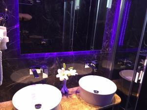 two sinks in a bathroom with purple lighting at Vergos Hotel in Vourvourou