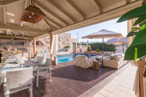 a patio with a table and chairs and a pool at Marilyn Manor, Exclusive Hideway, By ThinkVilla in Gouves