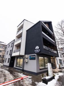 a black and white building with a sign on it at Nubia Central Apartments in Bistriţa