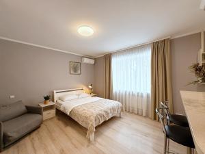 a bedroom with a bed and a couch at Kyiv Lesi 3 Studio Apartment in Kyiv