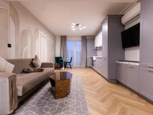 a living room with a couch and a kitchen at Nubia Central Apartments in Bistriţa