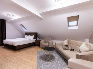 a living room with a bed and a couch at Nubia Central Apartments in Bistriţa