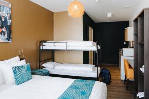 a room with two bunk beds and a chandelier at The Hague Teleport Hotel - Free Parking in The Hague