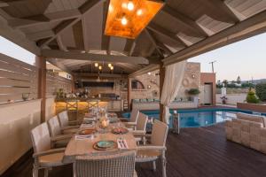 a patio with a table and chairs and a pool at Marilyn Manor, Exclusive Hideway, By ThinkVilla in Gouves