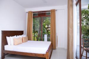 a bedroom with a bed in front of a window at Windsor Crest in Kandy