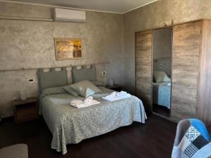 a bedroom with a bed with two towels on it at Albergo Vecchio Pavone in Borgaro Torinese