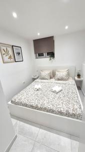 a white bedroom with a large bed in a room at Vacation Liberation Apartment in Split
