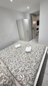 a large bed with two towels on top of it at Vacation Liberation Apartment in Split