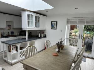 a kitchen with a wooden table and chairs in a kitchen at Mid- Village Croft in Cairndow