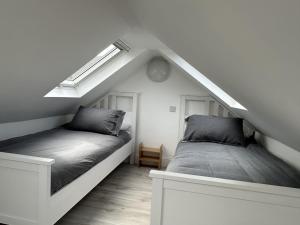 a bedroom with two beds in the attic at Mid- Village Croft in Cairndow